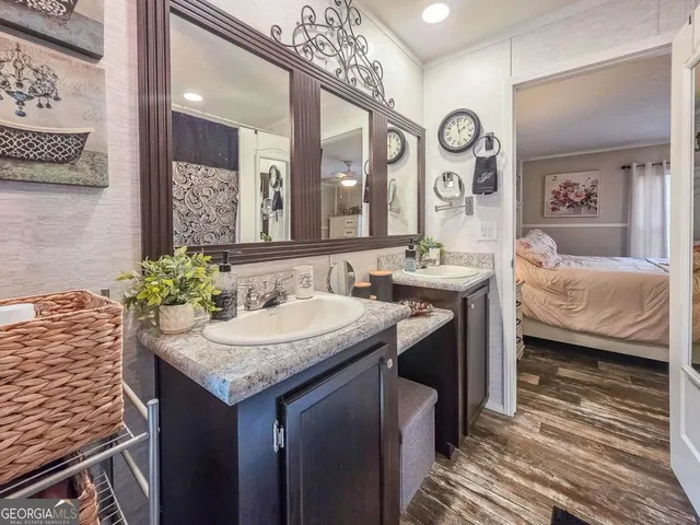 a en suite bathroom with a granite countertop sink and a mirror