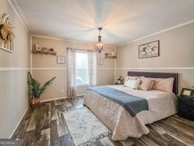 a bedroom with a large bed and a chandelier