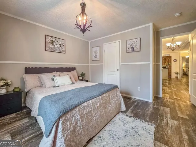 a bedroom with a large bed and a chandelier