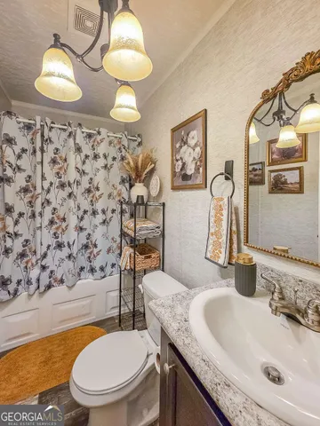 a bathroom with a granite countertop toilet sink and mirror