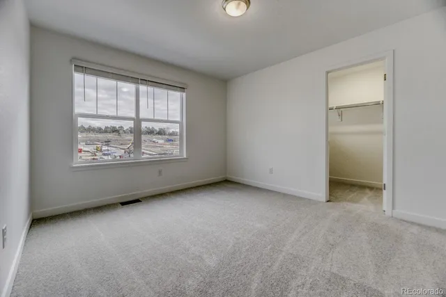 an empty room with windows and closet