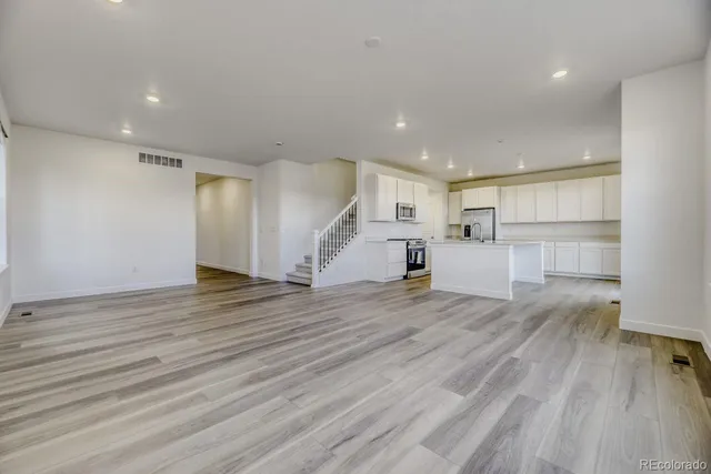 a view of a kitchen with wooden floor and a sink