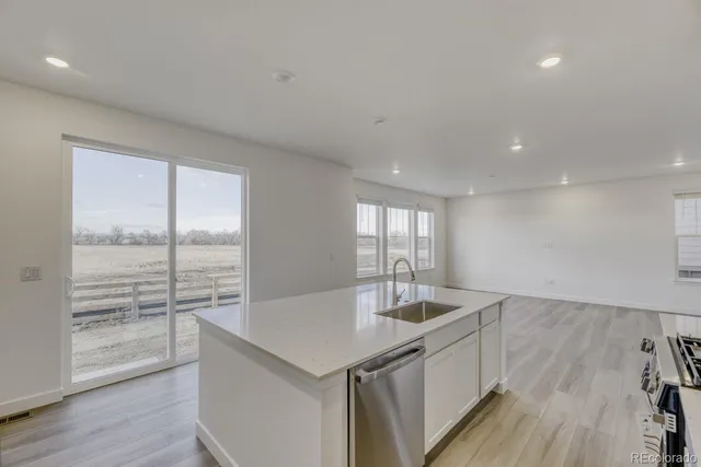 a kitchen with a sink and wooden floor