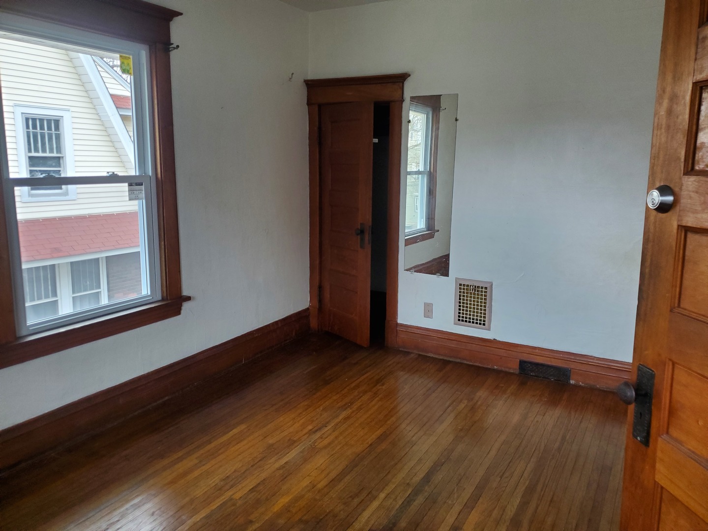 136 John Street DeKalb, IL 60115 - Photo 14 of 25 a view of an empty room with wooden floor and a window