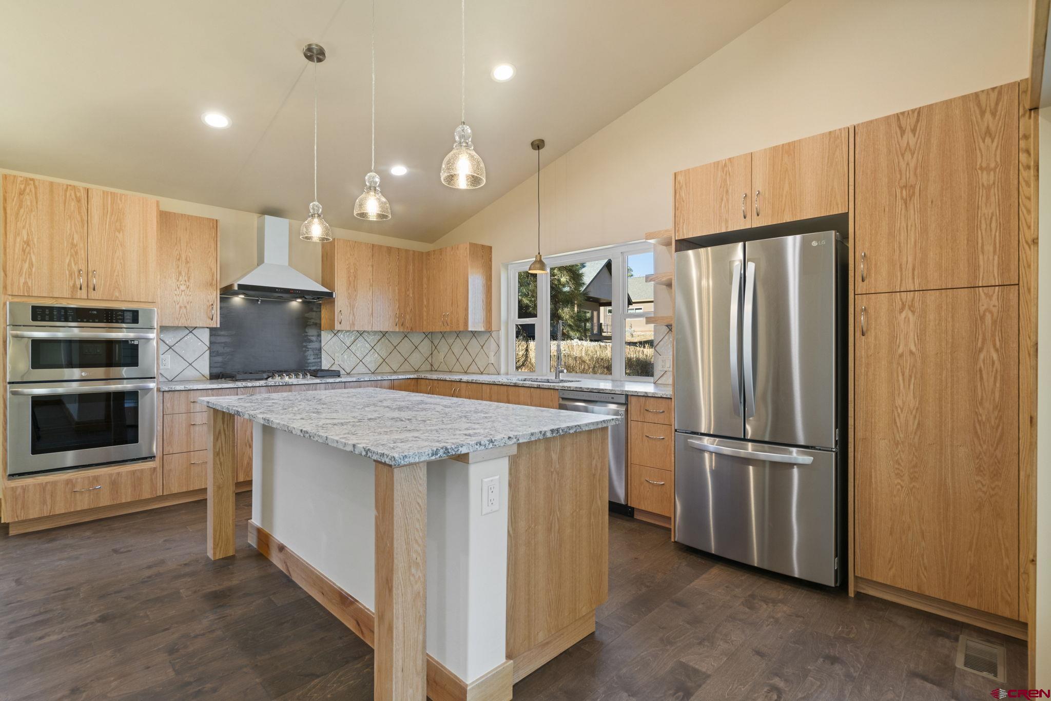 283 Edgemont Meadows Road Durango, CO 81301 - Photo 12 of 34 a kitchen with stainless steel appliances granite countertop a refrigerator a stove and a sink with wooden floor