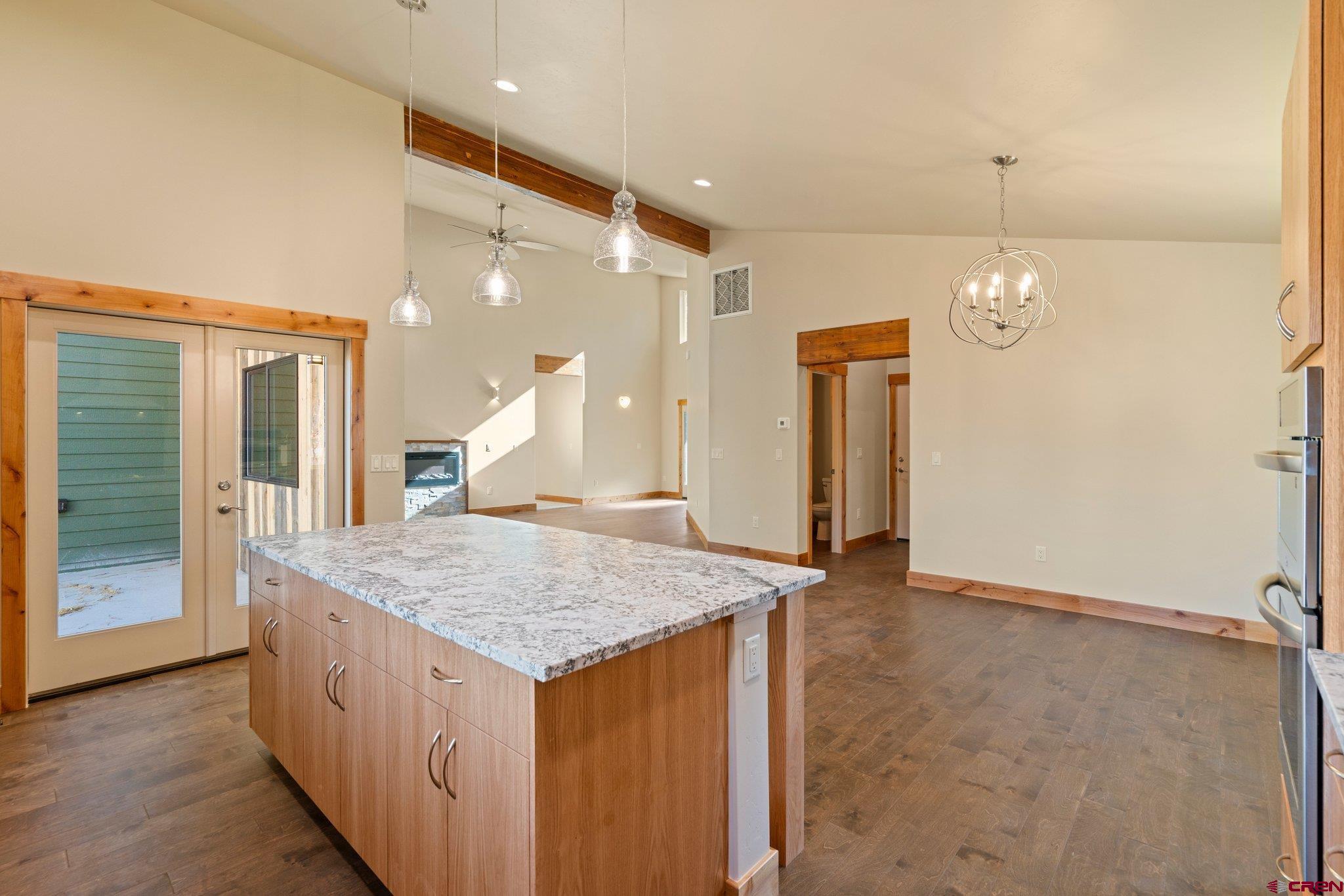283 Edgemont Meadows Road Durango, CO 81301 - Photo 17 of 34 a room with kitchen island a sink a refrigerator and wooden floor