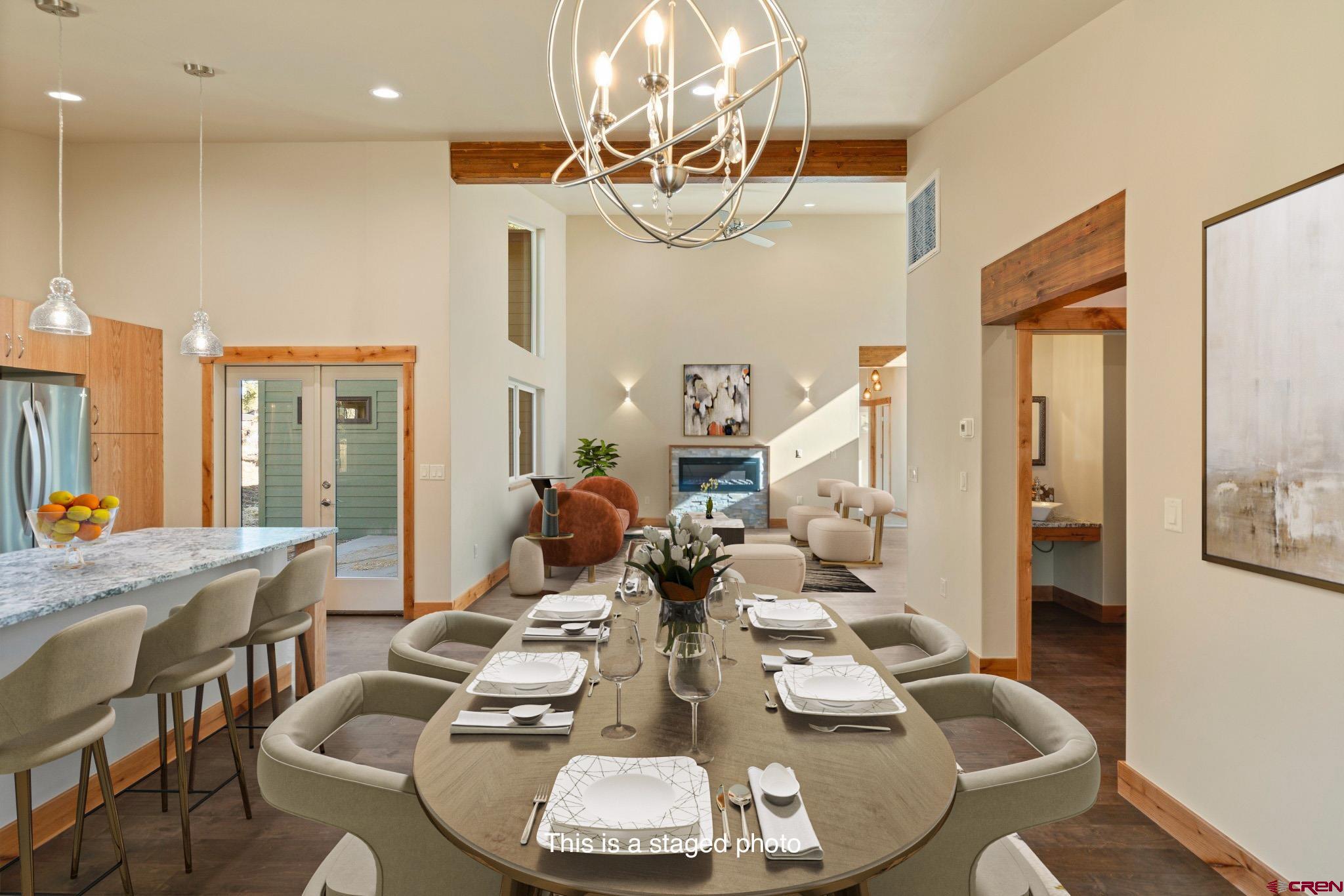 283 Edgemont Meadows Road Durango, CO 81301 - Photo 18 of 34 a dining room with wooden floor a chandelier a glass table and chairs