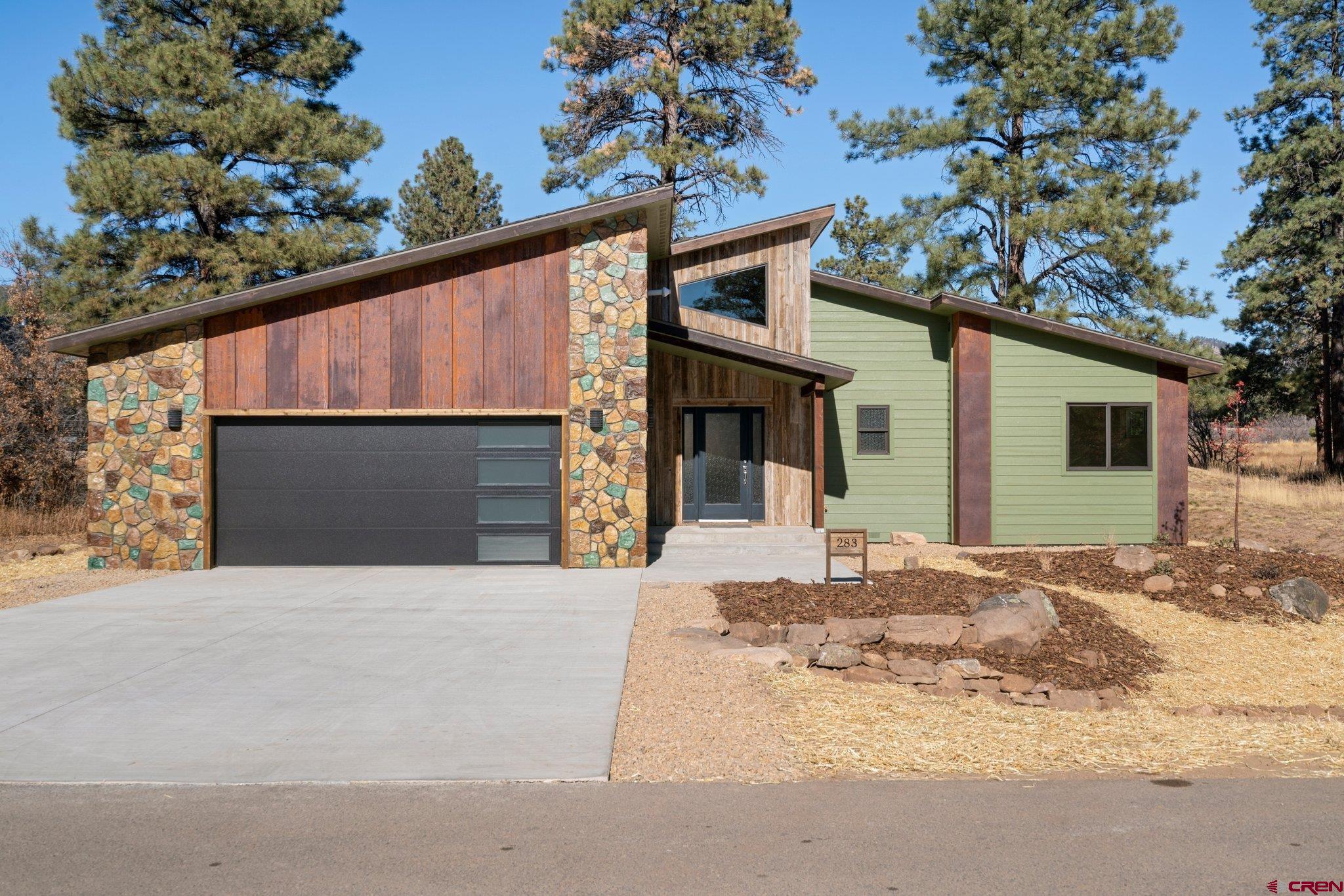 283 Edgemont Meadows Road Durango, CO 81301 - Photo 2 of 34 a front view of a house with a yard and garage