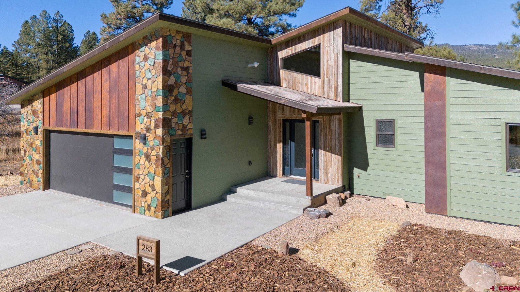 283 Edgemont Meadows Road Durango, CO 81301 - Photo 3 of 34 a view of a house with wooden walls and floor to ceiling window