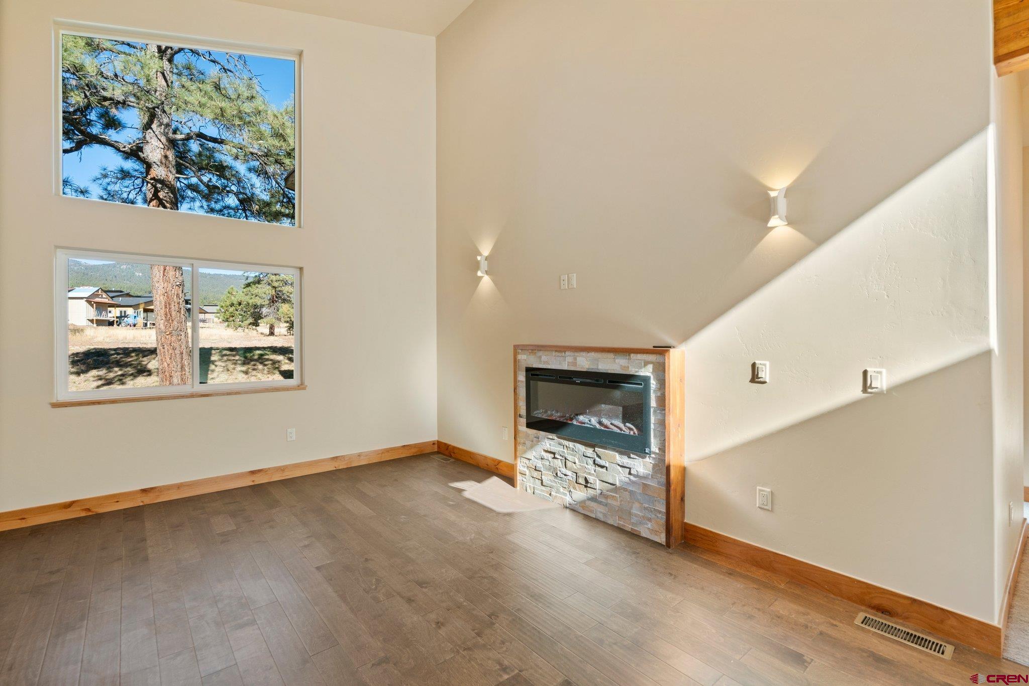 283 Edgemont Meadows Road Durango, CO 81301 - Photo 10 of 34 an empty room with windows and fireplace