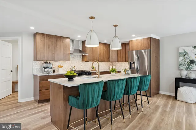 a kitchen with stainless steel appliances a dining table chairs refrigerator and sink