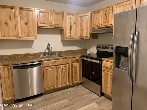 a kitchen with stainless steel appliances granite countertop a refrigerator sink and cabinets
