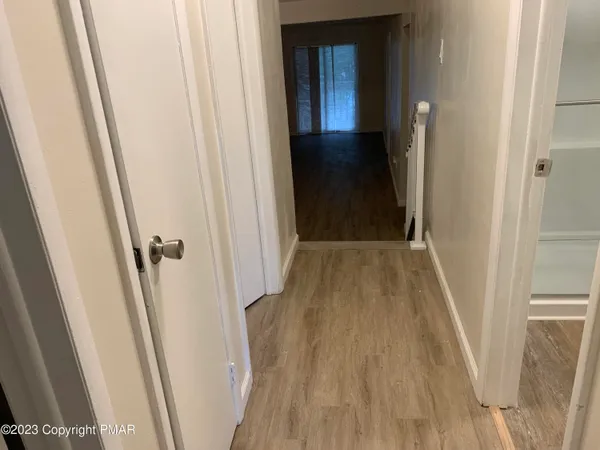a view of a hallway with wooden floor and staircase