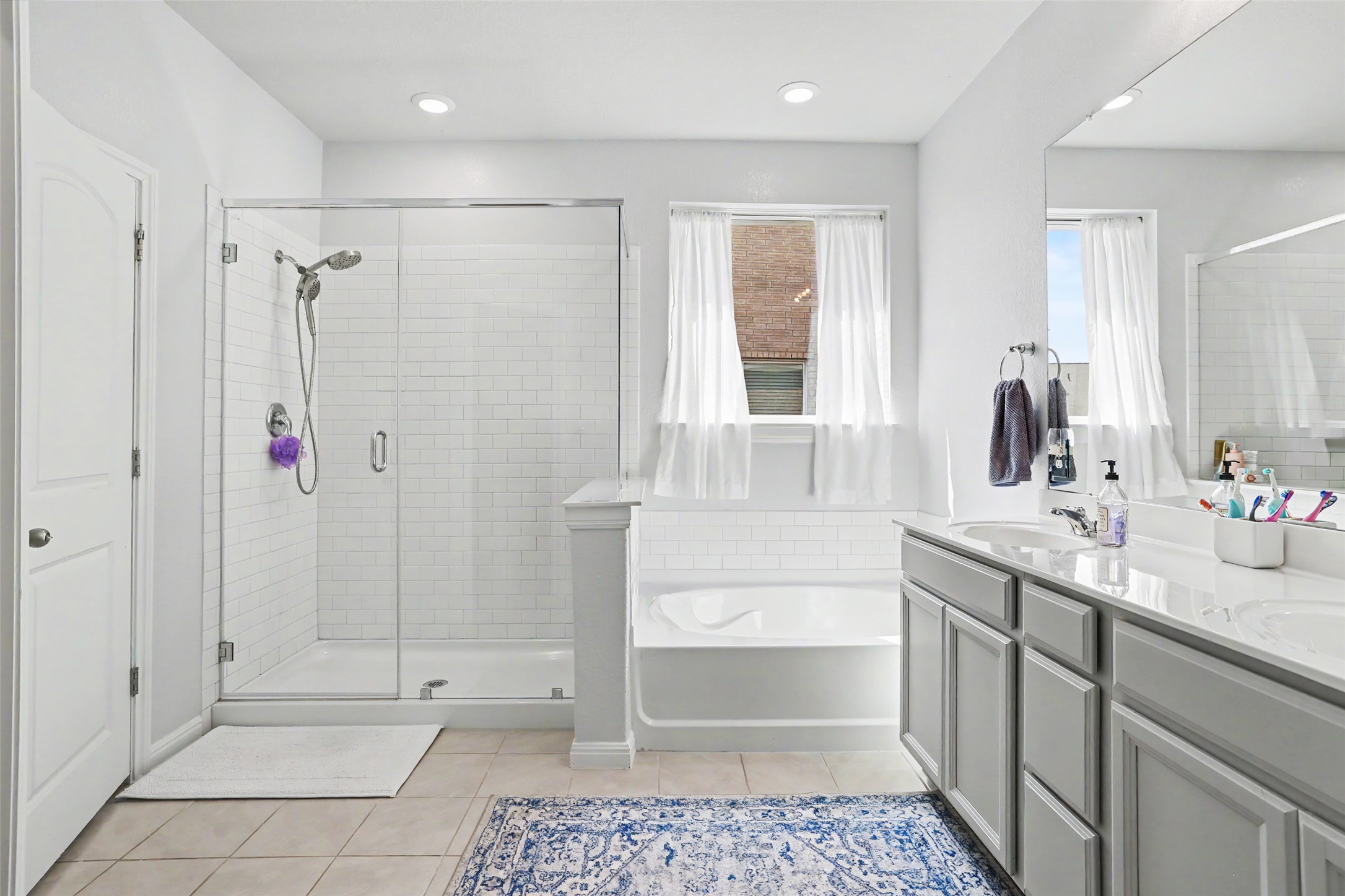 112 Rocking R Court Georgetown, TX 78633 - Photo 20 of 40 Bright and clean bathroom featuring a glass-enclosed shower, a relaxing soaking tub, and a vanity with dual sinks.