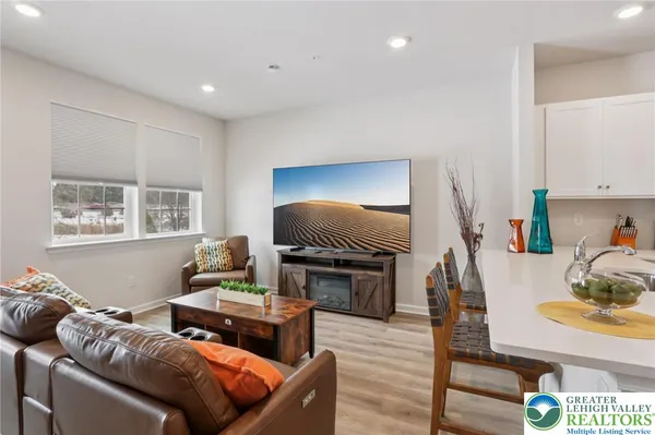 a dining hall with stainless steel appliances kitchen island granite countertop a table chairs and a refrigerator