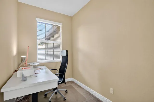 a view of a workspace with furniture and a window