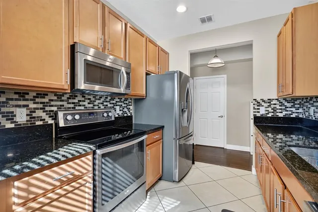 a kitchen with stainless steel appliances granite countertop a stove a refrigerator and a microwave