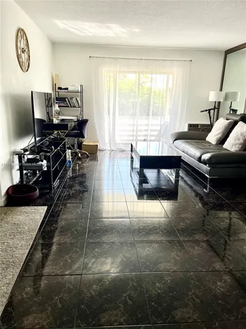 a living room with furniture a wooden floor and a large window