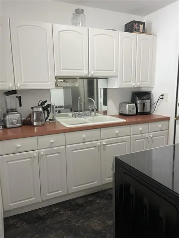 a kitchen with stainless steel appliances granite countertop white cabinets sink and dishwasher