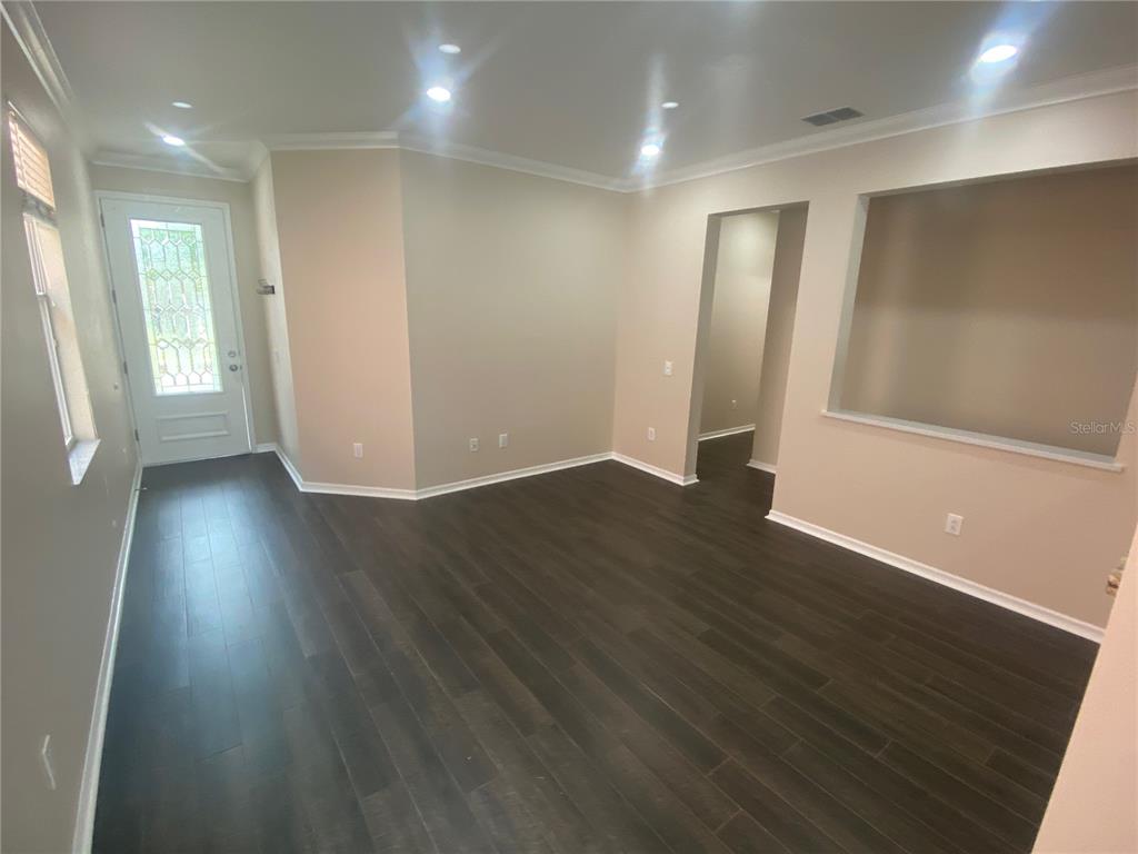 2409 Spring Hollow Loop Wesley Chapel, FL 33544 - Photo 6 of 47 an empty room with wooden floor and windows
