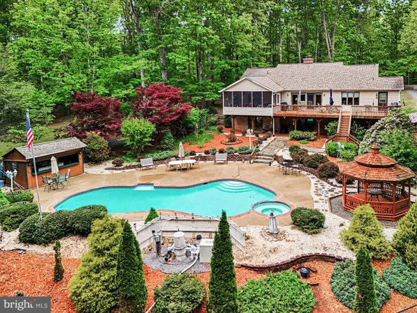 an aerial view of a house with garden space and swimming pool