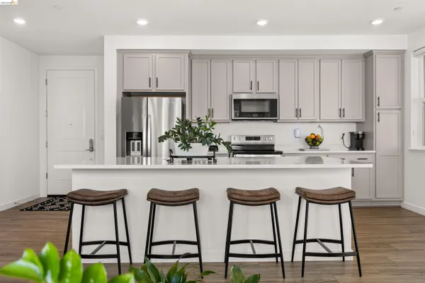 a kitchen with stainless steel appliances granite countertop a table chairs sink and cabinets