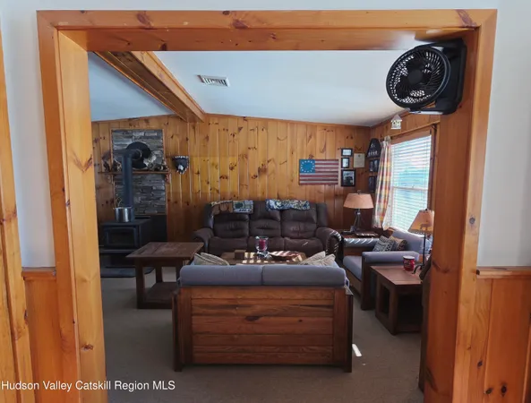 a living room with furniture a flat screen tv and kitchen view