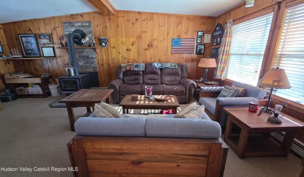 a living room with furniture a air conditioner vent and a window