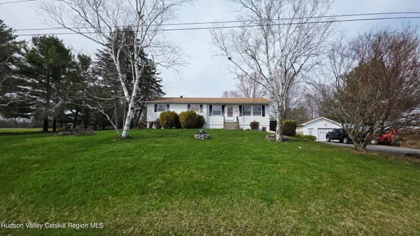 a front view of a house with a yard covered in snow