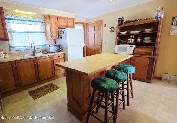 a kitchen with stainless steel appliances granite countertop a refrigerator a stove a sink dishwasher and white cabinets with wooden floor