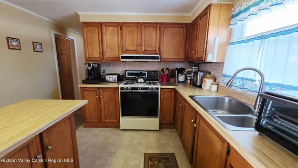 a living room with furniture a flat screen tv and kitchen view