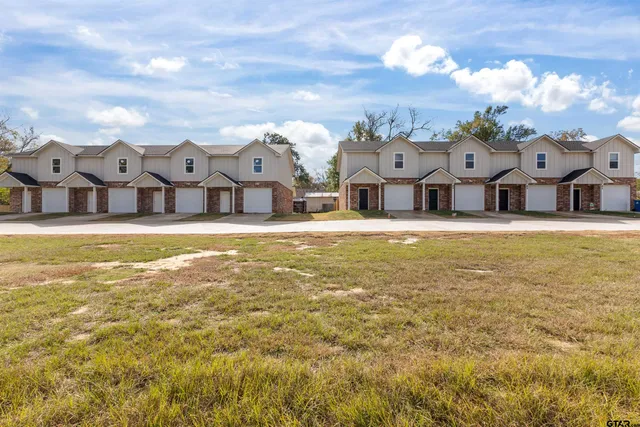 a view of a house with a big yard and large trees