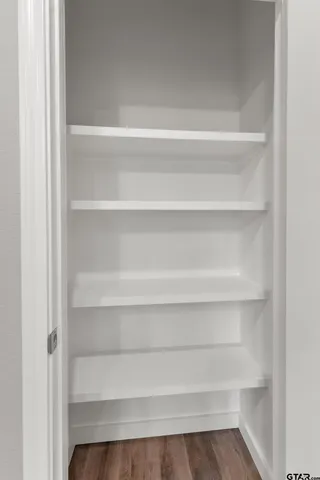 a view of walk in closet with empty racks