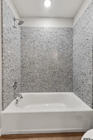 a bathroom with a bathtub and shower