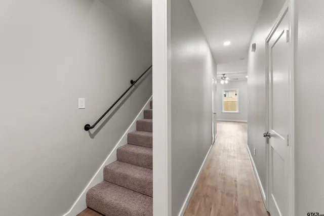 a view of a hallway with windows and stairs