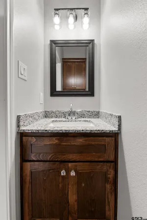 a bathroom with a granite countertop sink a toilet and a microwave