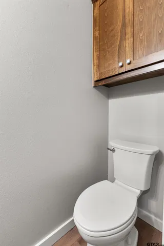 a white toilet sitting next to a cabinet