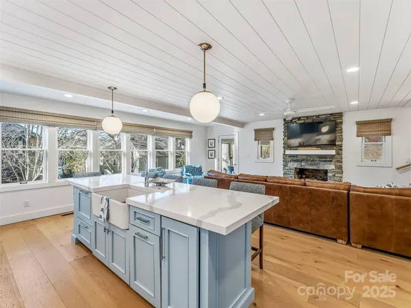 a kitchen with kitchen island granite countertop a sink and a large window