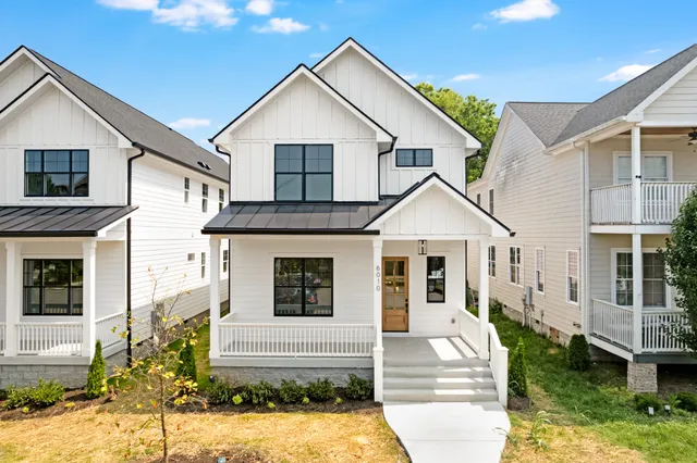 a view of a white house with large windows and yard