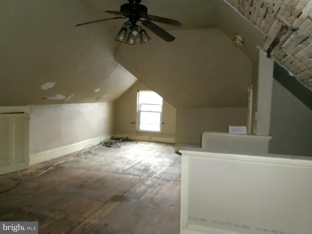 en empty room with windows and ceiling fan