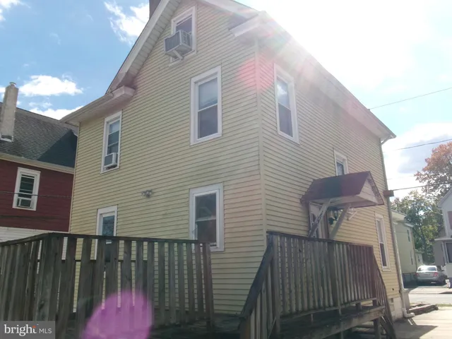 a view of a wooden house with a small yard