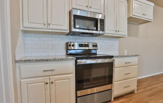 a kitchen with kitchen island granite countertop a sink and a stove