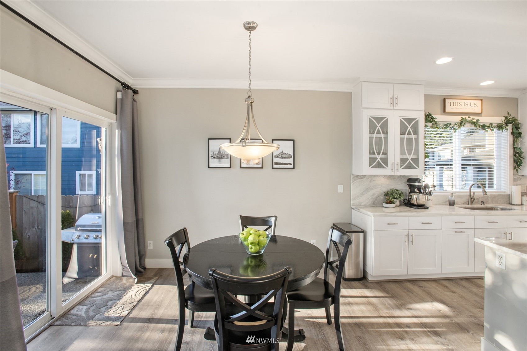 1328 North 39th Street Renton, WA 98056 - Photo 14 of 40 a kitchen with stainless steel appliances a dining table chairs and white cabinets