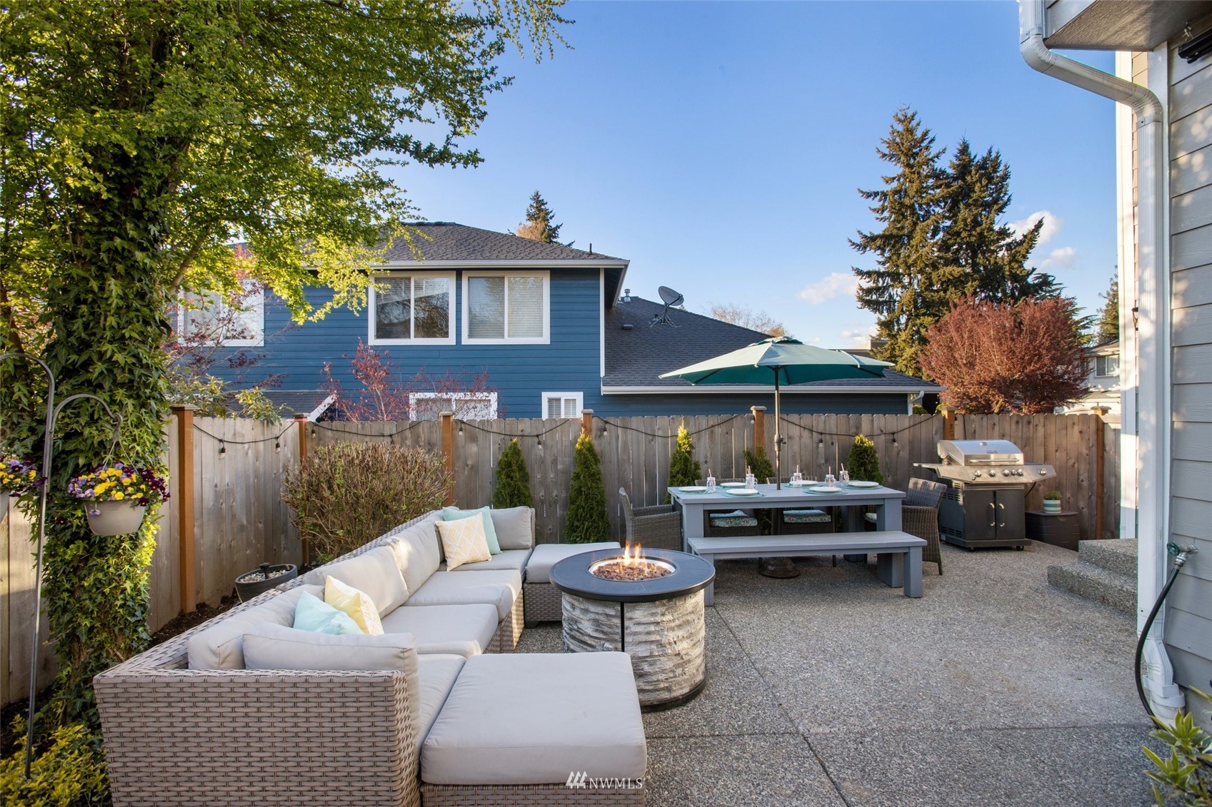 1328 North 39th Street Renton, WA 98056 - Photo 32 of 40 a view of a patio with couches table and chairs under an umbrella with a fire pit