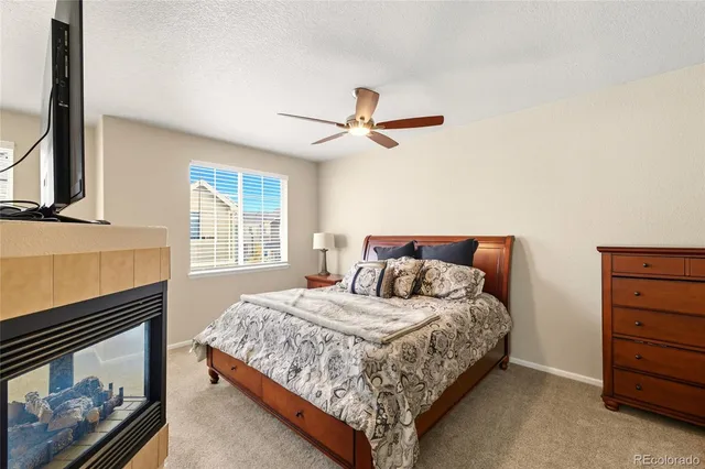 a bedroom with a bed chandelier and a window