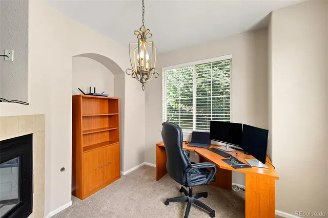 a view of a workspace with furniture and a window