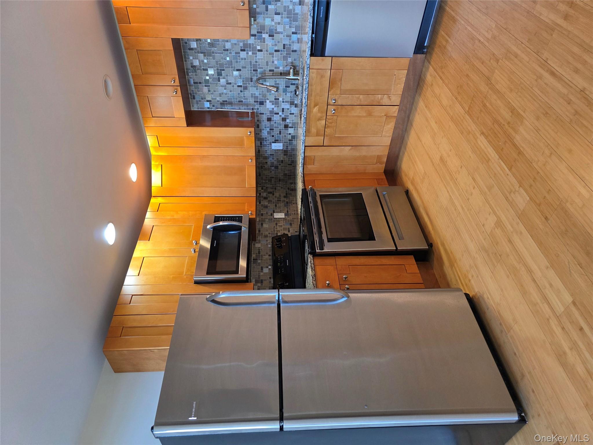 231 Reynolds Road, Unit 9 Fallsburg, NY 12759 - Photo 1 of 15 Kitchen with appliances with stainless steel finishes, light stone countertops, tasteful backsplash, light wood-style floors, and recessed lighting