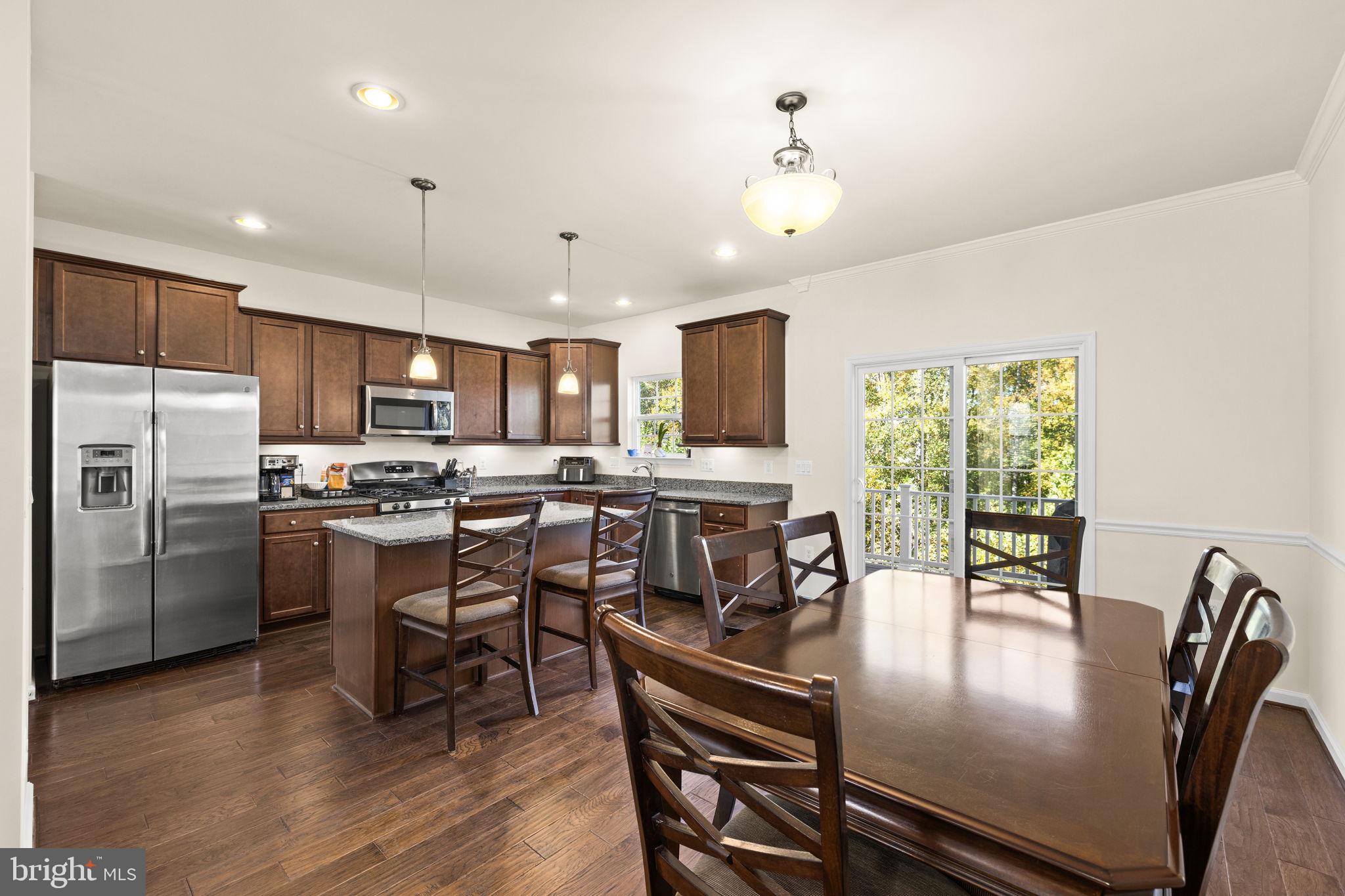 302 Tree Line Drive Fredericksburg, VA 22405 - Photo 14 of 38 a kitchen with a table chairs microwave and refrigerator