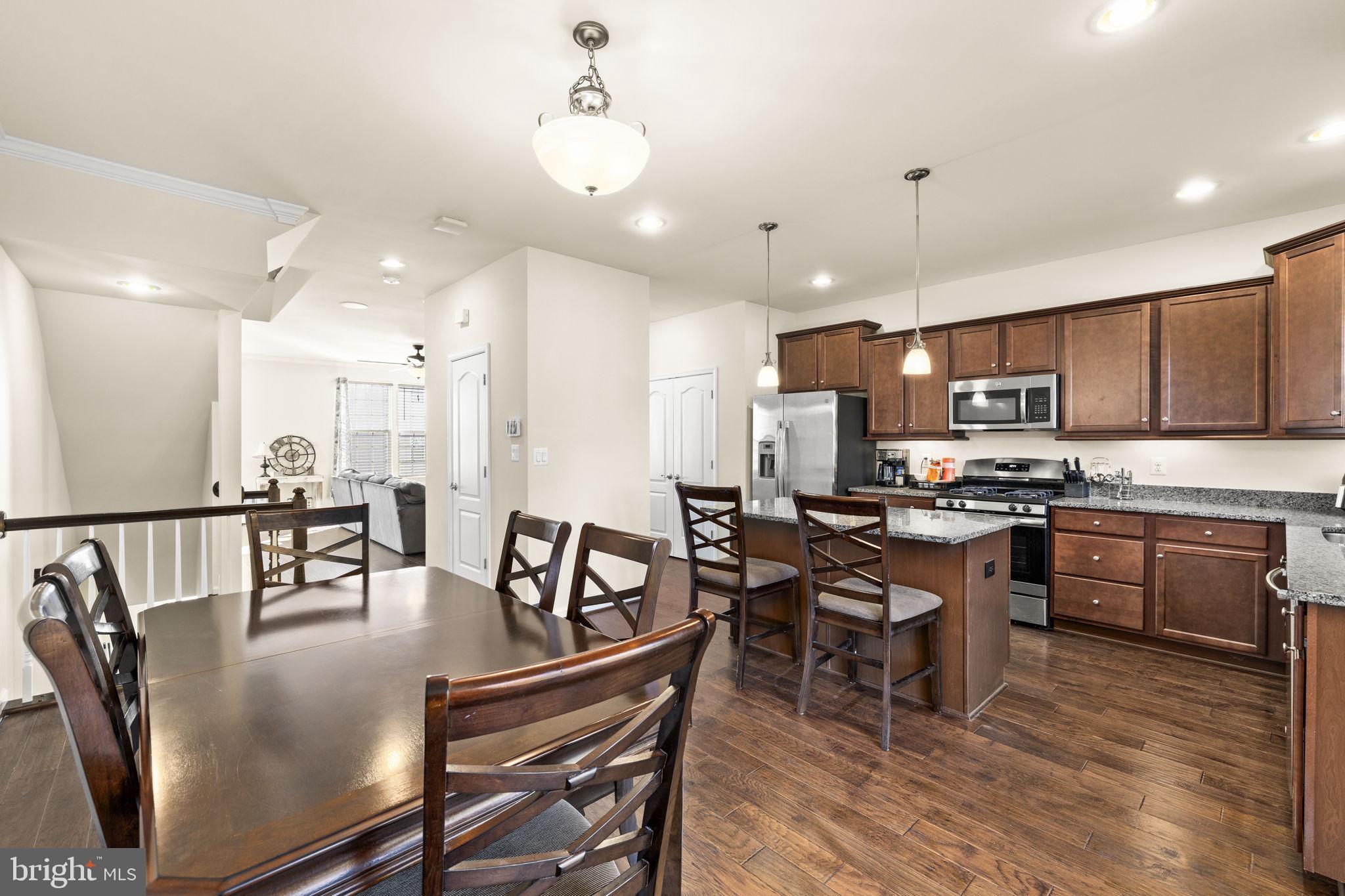 302 Tree Line Drive Fredericksburg, VA 22405 - Photo 17 of 38 a kitchen with stainless steel appliances granite countertop a stove a refrigerator a kitchen island a dining table and chairs with wooden floor