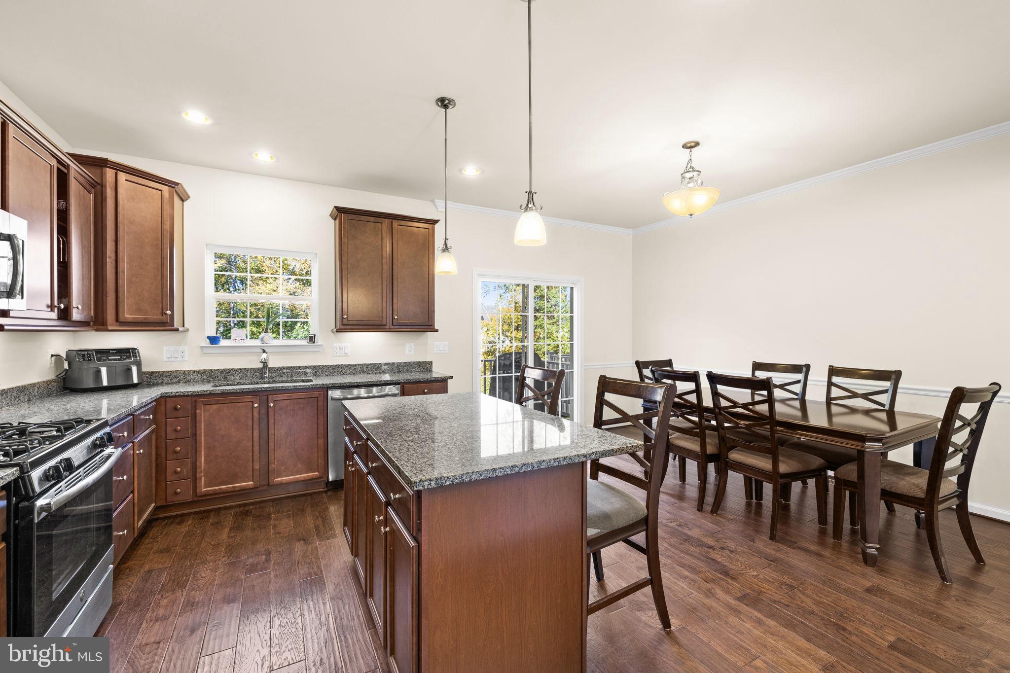 302 Tree Line Drive Fredericksburg, VA 22405 - Photo 22 of 38 a kitchen with granite countertop a stove a sink a dining table and chairs
